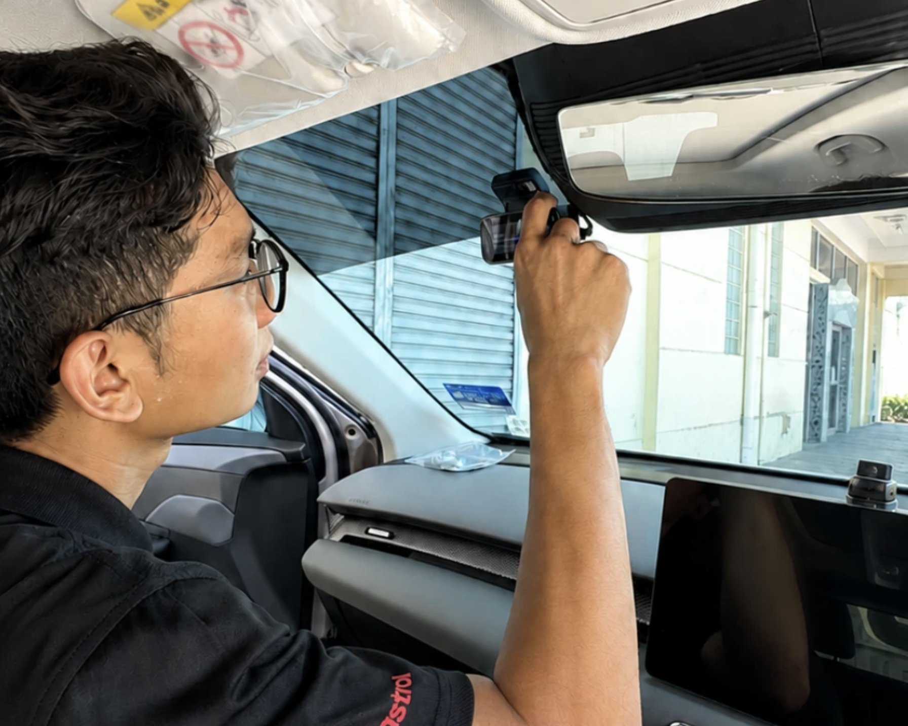 Installer neatly routing the dashcam cable behind the windscreen trim